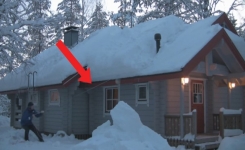 Un homme montre une méthode sans effort pour enlever la neige lourde du toit