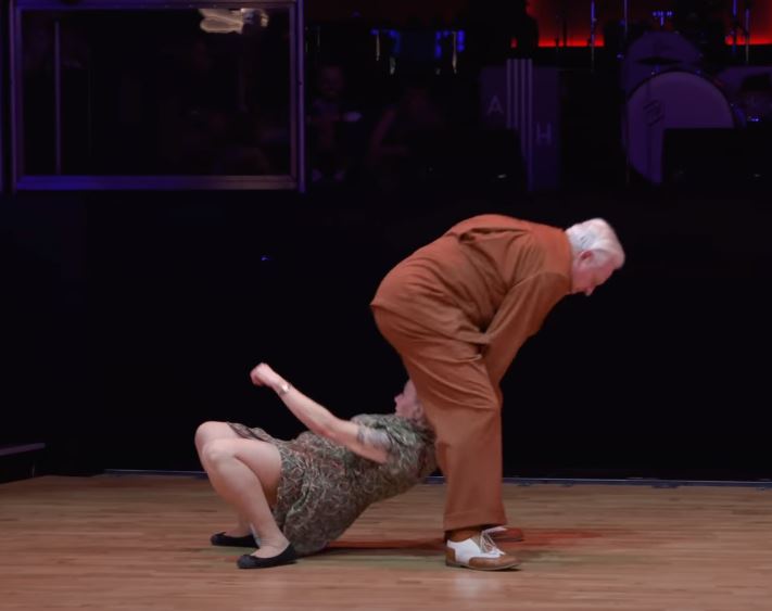 Un homme âgé arrive par derrière et réalise des pas de danse que la foule n’est as prête d’oublier