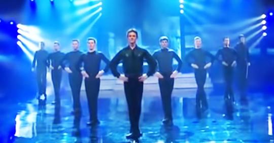 9 hommes se mettent en ligne pour danser mais regarde l’homme devant lorsqu’une femme avec un tambour entre en scène
