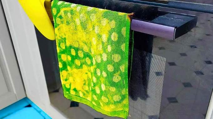 Pour quelle raison éviter de suspendre un torchon sur la porte du four ?