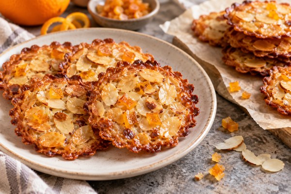Florentins dorés aux amandes effilées et aux écorces d’orange confites sur une assiette.
